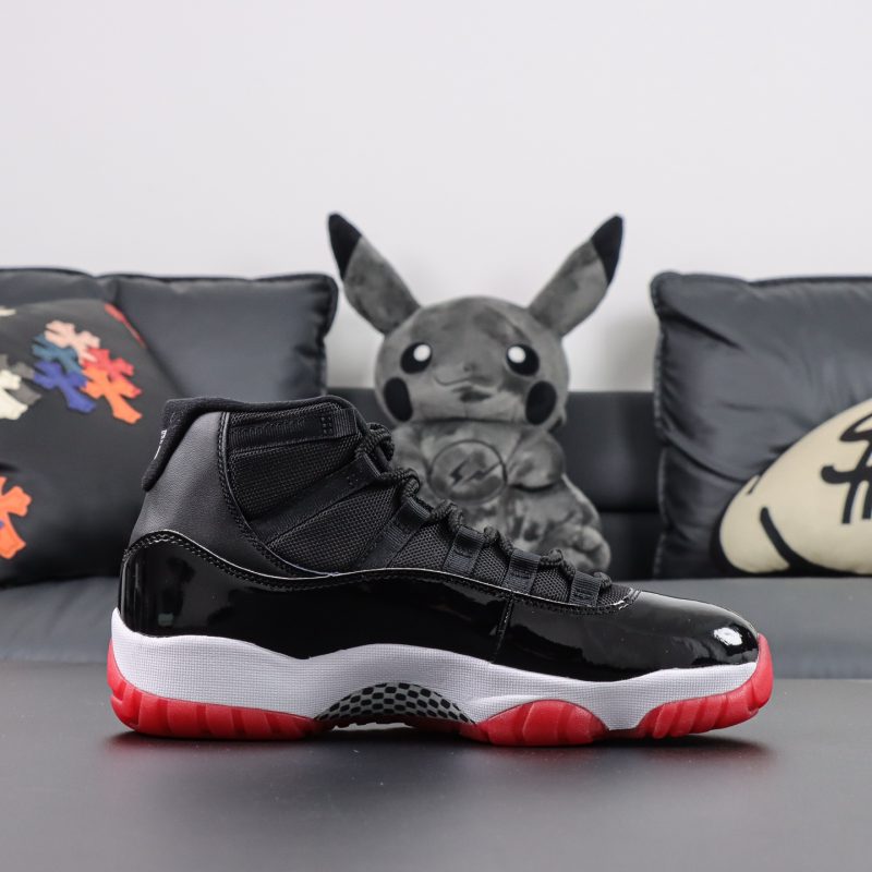 Side view of Jordan 11 Bred replica with red sole and OG black upper