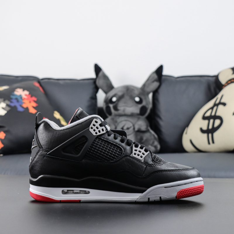 Side view of Jordan 4 Bred Reimagined reps with red midsole accents