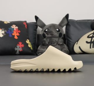 Single shoe side view of Yeezy Slide Bone in beige EVA