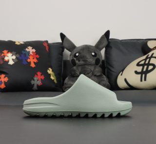 Single shoe side view of Yeezy Slide Salt in light grey